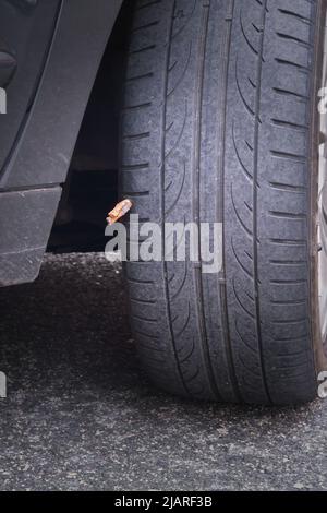 Foratura riparata sulla ruota di una vettura con stoppino in gomma impregnato di colla Foto Stock