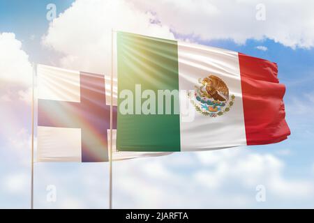 Cielo azzurro soleggiato e bandiere del messico e della finlandia Foto Stock