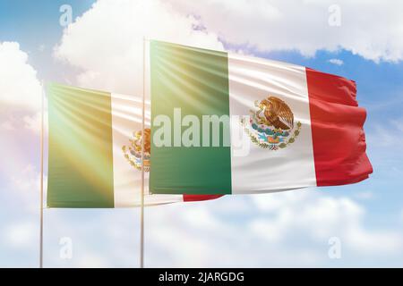 Cielo azzurro soleggiato e bandiere di messico e messico Foto Stock