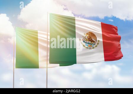 Cielo azzurro soleggiato e bandiere del messico e della nigeria Foto Stock