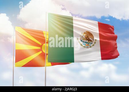 Cielo azzurro soleggiato e bandiere del messico e della macedonia settentrionale Foto Stock