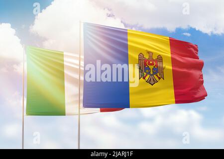 Cielo azzurro soleggiato e bandiere della moldavia e dell'italia Foto Stock