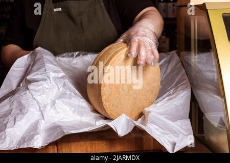 La testa di formaggio intera è confezionata sul banco. Foto Stock