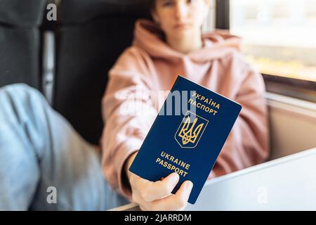 Presentazione del passaporto biometrico della carta d'identità del cittadino ucraino in trasporto, treno. Viaggio gratuito per i residenti temporaneamente reinsediati Foto Stock