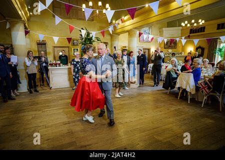 Il Principe di Galles balla con Bridget Tibbs durante una danza del tè giubilare ospitata dalla Fondazione del Principe per celebrare il Giubileo del platino, ad Highgrove vicino a Tetbury, Gloucestershire. Al Principe Carlo si unì Jools Holland, Ruby Turner e Patrick Grant alla celebre danza del tè, una delle tante tenute in tutto il Regno Unito dalla Prince's Foundation, il cui obiettivo è combattere la solitudine e l'isolamento nelle comunità circostanti. Data foto: Martedì 31 maggio 2022. Foto Stock