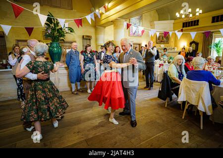 Il Principe di Galles balla con Bridget Tibbs durante una danza del tè giubilare ospitata dalla Fondazione del Principe per celebrare il Giubileo del platino, ad Highgrove vicino a Tetbury, Gloucestershire. Al Principe Carlo si unì Jools Holland, Ruby Turner e Patrick Grant alla celebre danza del tè, una delle tante tenute in tutto il Regno Unito dalla Prince's Foundation, il cui obiettivo è combattere la solitudine e l'isolamento nelle comunità circostanti. Data foto: Martedì 31 maggio 2022. Foto Stock