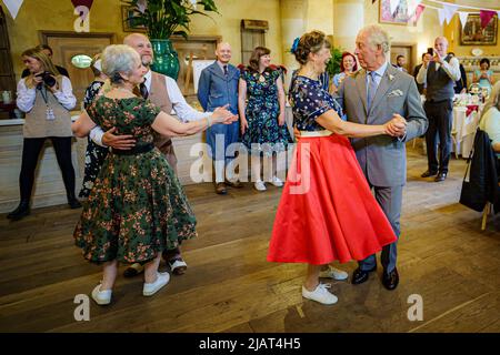 Il Principe di Galles balla con Bridget Tibbs durante una danza del tè giubilare ospitata dalla Fondazione del Principe per celebrare il Giubileo del platino, ad Highgrove vicino a Tetbury, Gloucestershire. Al Principe Carlo si unì Jools Holland, Ruby Turner e Patrick Grant alla celebre danza del tè, una delle tante tenute in tutto il Regno Unito dalla Prince's Foundation, il cui obiettivo è combattere la solitudine e l'isolamento nelle comunità circostanti. Data foto: Martedì 31 maggio 2022. Foto Stock