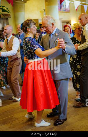 Il Principe di Galles balla con Bridget Tibbs durante una danza del tè giubilare ospitata dalla Fondazione del Principe per celebrare il Giubileo del platino, ad Highgrove vicino a Tetbury, Gloucestershire. Al Principe Carlo si unì Jools Holland, Ruby Turner e Patrick Grant alla celebre danza del tè, una delle tante tenute in tutto il Regno Unito dalla Prince's Foundation, il cui obiettivo è combattere la solitudine e l'isolamento nelle comunità circostanti. Data foto: Martedì 31 maggio 2022. Foto Stock