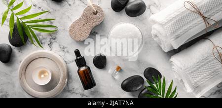 articoli per trattamenti benessere - pietre per massaggi caldi con sale e oli su un tavolo in marmo. banner con vista dall'alto Foto Stock