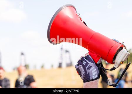 uomo in piedi urlando con il boccaglio. Foto Stock