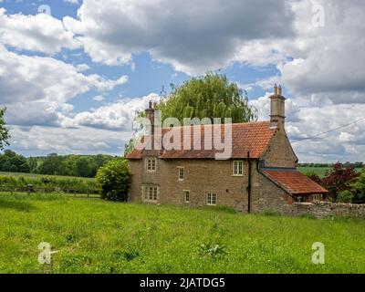 Casa costruita in pietra color miele con vista sulla campagna aperta ai margini del villaggio di Castle Ashby, Northamptonshire, Regno Unito Foto Stock