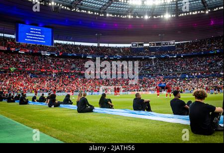 Aufgrund der verspäteten Anstoßzeit sitzen Volontarii für die coreo während der zweiten Aufwärmphase am Spielfeldrand FC Liverpool - Real Madrid Pa Foto Stock