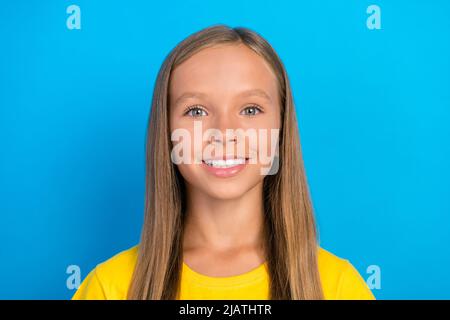 Foto di simpatico adorabile positiva piccola signora toothy beaming sorriso indossare giallo t-shirt isolato blu sfondo di colore Foto Stock