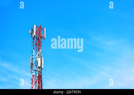 Torre per telecomunicazioni con antenne ripetitore di segnale contro il cielo blu come spazio di copia Foto Stock