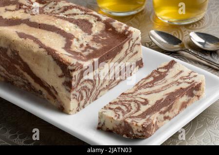 Piatto con tradizionale halva al cioccolato turco e una fetta di primo piano e tè Foto Stock