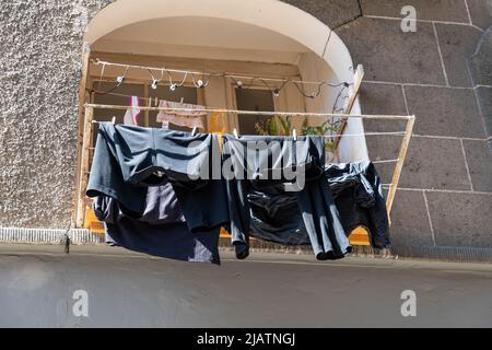 Lavanderia appeso ad asciugare di fronte alla finestra sul muro della casa Foto Stock