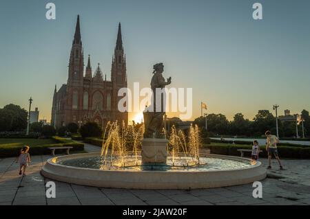 Piazza al tramonto con i bambini che giocano Foto Stock