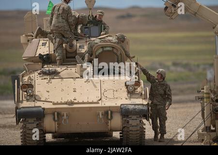 Soldiers from Charlie Company, 2-116th Combined Arms Battaglione lavoro per preparare i loro veicoli Bradley Fighting per le qualifiche di gunnery. Idaho Army National Guard Soldates from the 2-116th Combined Arms Battaglione in the field per la formazione annuale e la preparazione finale per lo spiegamento a sostegno dell'operazione Spartan Shield. Foto Stock