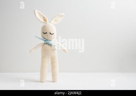 Carino coniglietto amigurumi lavorato a mano a crochet con sciarpa blu Foto Stock