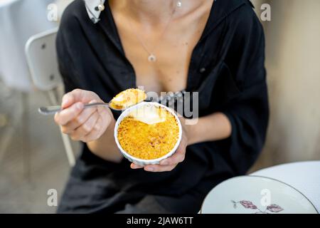 Mangiare dessert con creme brulee al ristorante all'aperto Foto Stock
