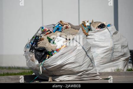 Grandi sacchi neri di rifiuti vicino al dumpster (iscrizione in russo - IL  RILASCIO DI COSTRUZIONE E DI RIFIUTI DI GRANDI DIMENSIONI È PROIBITO Foto  stock - Alamy