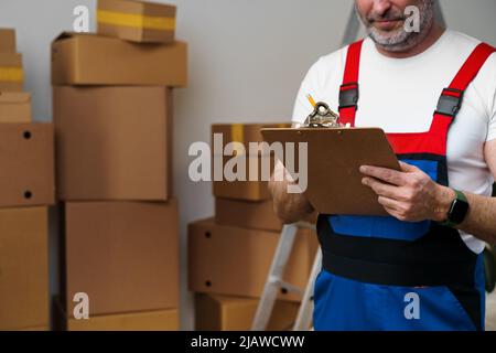 L'uomo di mezza età si mover in uniforme facendo note sugli appunti Foto Stock