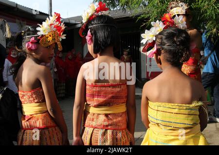 Jakarta, Indonesia. 01/06/2022, un certo numero di studenti partecipano ad una cerimonia di bandiera indossando abiti tradizionali provenienti da varie regioni per commemorare il compleanno di Pancasila, presso la scuola di emergenza Kartini, sotto la strada a pedaggio Ancol, Jakarta, Indonesia. La Kartini Emergency School è gestita dai fratelli gemelli Rosy e Ryan, che accolgono studenti svantaggiati di vari gruppi senza dover pagare un centesimo. Anche se la loro scuola si trova alla periferia di sotto la strada a pedaggio e le piste ferroviarie, l'entusiasmo dei bambini coinvolti nella serie di eventi è stato pieno di significato in Foto Stock