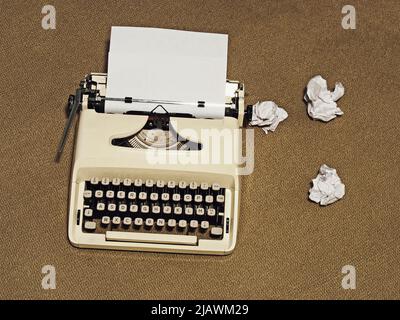 macchina da scrivere vintage con pagina bianca e palle di carta Foto Stock