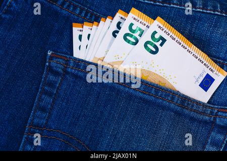 Le fatture in euro in tasca dei jeans sfondo. Le banconote in euro in jeans tasca posteriore. Concetto di gente ricca, salvataggio o spendere soldi. Euro Bills cadano fuori. Foto Stock