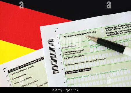 Modulo di dichiarazione della dichiarazione della tassa sul reddito annuale tedesca con penna a bandiera a primo piano. Il concetto di rendicontazione fiscale in Germania e in Europa Foto Stock