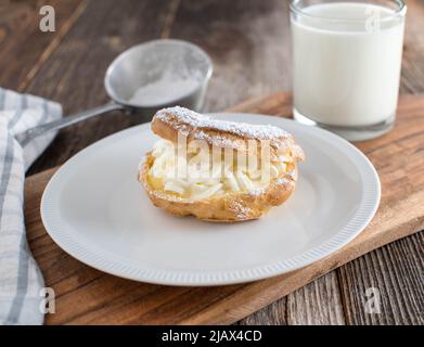 Bicchiere di latte con un pezzo di pasta Foto Stock