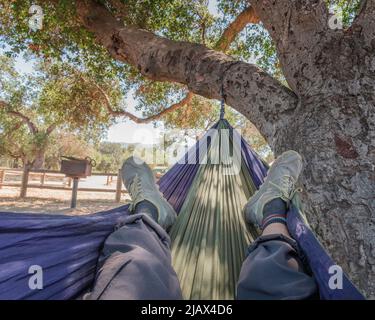 Foto POV di un uomo in un'amaca rilassante. Foto Stock