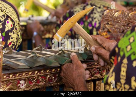 Un musicista suona un selantano o un demong, uno strumento tradizionale balinese, come parte di un ensemble musicale o di un gamelan, durante uno spettacolo Foto Stock