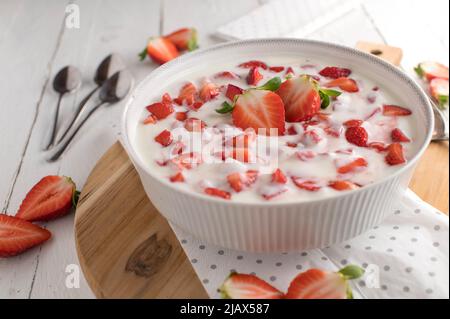 Yogurt alla fragola in una ciotola sul tavolo da cucina bianco. Dessert sano Foto Stock