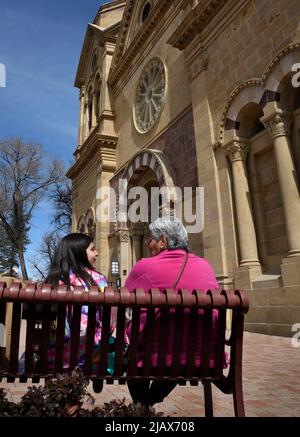 Una anziana donna nativa americana siede con la nipote di fronte alla Basilica della Cattedrale di San Francesco d'Assisi a Santa Fe, New Mexico. Foto Stock