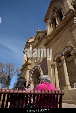 Una anziana donna nativa americana siede con la nipote di fronte alla Basilica della Cattedrale di San Francesco d'Assisi a Santa Fe, New Mexico. Foto Stock