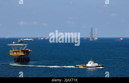 Piattaforme petrolifere con barca di rifornimento per il trasporto di persone o materiali a piattaforme vicine, South China Sea, Malesia Foto Stock