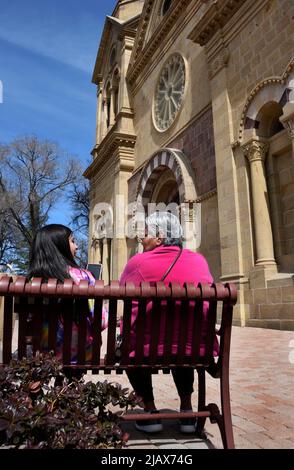 Una anziana donna nativa americana siede con la nipote di fronte alla Basilica della Cattedrale di San Francesco d'Assisi a Santa Fe, New Mexico. Foto Stock