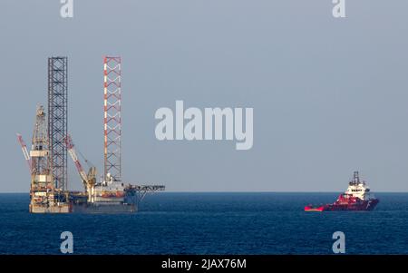 Piattaforme petrolifere con barca di rifornimento per il trasporto di persone o materiali a piattaforme vicine, South China Sea, Malesia Foto Stock