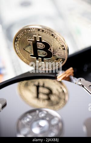 Bitcoin che si riflette sul disco rigido. Concetto di estrazione della valuta Crypto, tecnologia a catena di blocchi e concetto di archiviazione della contabilità. Foto Stock