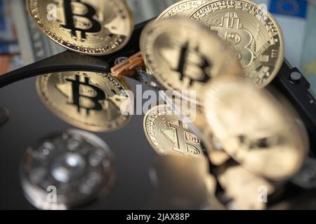 Bitcoin cripto valuta che riflette su disco d'argento. Disco rigido che riflette le monete BTC d'oro. Concetto di valuta crittografica digitale e catena di blocchi Foto Stock