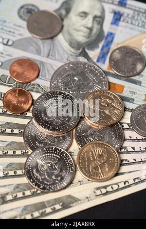 Monete da un dollaro e mezzo dollaro su banconote da 100 dollari. Pagamento in contanti IN valuta USA. Carta moneta e monete metalliche. Commercio negli Stati Uniti e all'estero Foto Stock