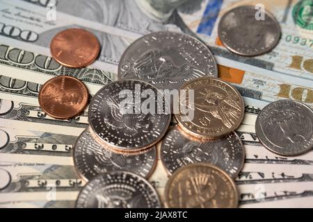 Monete da un dollaro e mezzo dollaro su banconote da 100 dollari. Pagamento in contanti IN valuta USA. Carta moneta e monete metalliche. Commercio negli Stati Uniti e all'estero Foto Stock