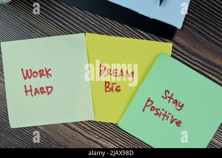 Concetto di lavoro duro, Dream grande, soggiorno positivo scrivere su note appiccicose isolato su tavola di legno. Foto Stock