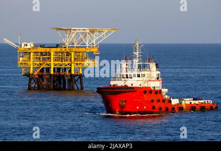 Piattaforme petrolifere con barca di rifornimento per il trasporto di persone o materiali a piattaforme vicine, South China Sea, Malesia Foto Stock