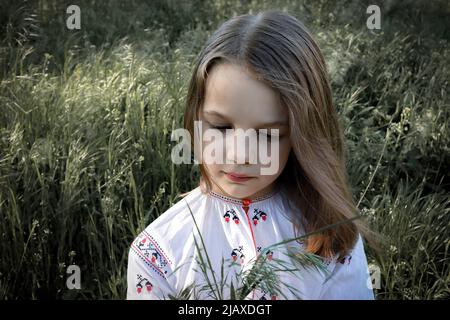 Ritratto di una ragazza in una camicia ricamata con spiondini all'aperto Foto Stock