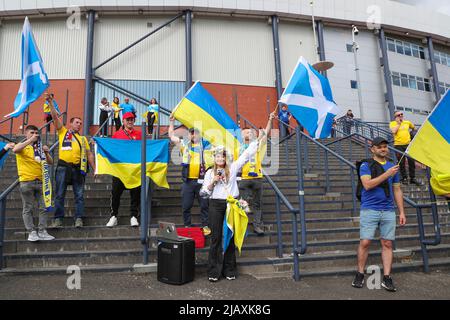 Glasgow, Regno Unito. 01st giugno 2022. Mentre Hampden Park, lo stadio nazionale di calcio della Scozia, si prepara per la semifinale della Coppa del mondo FIFA tra Scozia e Ucraina, i sostenitori ucraini arrivano presto e si preparano per la partita con picnic sulle vicine aree erbose e canti comunali dell'inno nazionale ucraino. Credit: Findlay/Alamy Live News Foto Stock