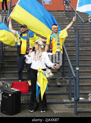 Glasgow, Regno Unito. 01st giugno 2022. Mentre Hampden Park, lo stadio nazionale di calcio della Scozia, si prepara per la semifinale della Coppa del mondo FIFA tra Scozia e Ucraina, i sostenitori ucraini arrivano presto e si preparano per la partita con picnic sulle vicine aree erbose e canti comunali dell'inno nazionale ucraino. Credit: Findlay/Alamy Live News Foto Stock