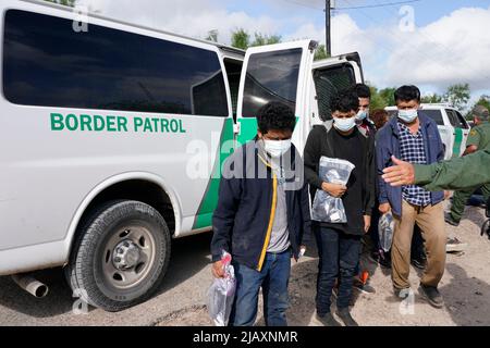 I migranti vengono trattenuti mentre vengono processati dalla pattuglia di confine degli Stati Uniti prima di prendere un autobus per un centro di detenzione il secondo giorno dell’attuazione della “credibile Fear and Asylum Processing Interim Final Rule”, il 1 giugno 2022 a la Joya, Texas, USA. La regola prevede che i casi che possono beneficiare dell'asilo siano accelerati in mesi anziché in anni, nel tentativo di alleviare il ritardo dei casi in tribunale. Il titolo 42, il mandato dell’era Trump che era stato fissato per impedire ai migranti di entrare negli Stati Uniti, doveva scadere il 23 maggio ma era stato bloccato da una causa intentata da diversi stati che citavano che la mossa t Foto Stock