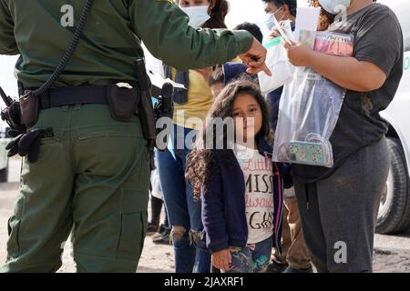 I migranti vengono trattenuti mentre vengono processati dalla pattuglia di confine degli Stati Uniti prima di prendere un autobus per un centro di detenzione il secondo giorno dell’attuazione della “credibile Fear and Asylum Processing Interim Final Rule”, il 1 giugno 2022 a la Joya, Texas, USA. La regola prevede che i casi che possono beneficiare dell'asilo siano accelerati in mesi anziché in anni, nel tentativo di alleviare il ritardo dei casi in tribunale. Il titolo 42, il mandato dell’era Trump che era stato fissato per impedire ai migranti di entrare negli Stati Uniti, doveva scadere il 23 maggio ma era stato bloccato da una causa intentata da diversi stati che citavano che la mossa t Foto Stock